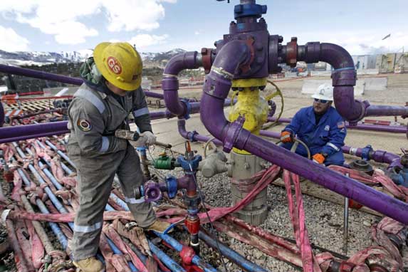 Workers tend to a well head during a hydraulic fracturing operation in western Colorado, March 29, 2013. (AP Photo/Brennan Linsley)